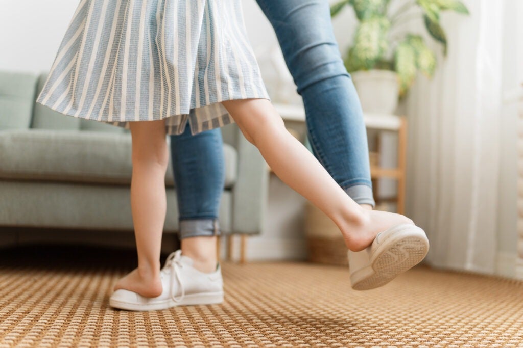 Mom and her daughter child girl are dancing.